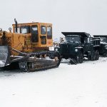 800px-Bulldozer_pulls_two_dump_trucks,_Alaska_1973