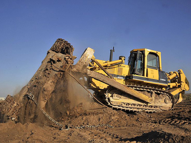 Bulldozer moving a large pile of dirt